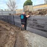 Jamesco Group Building a Retaining Wall in Melbourne using Charcoal Marina Smooth Concrete Sleepers Supplied by Sunset Sleepers