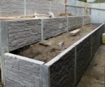 Backayrd Retaining Wall Construction Project in Progress Using the Charcoal Manhattan Stacked Stone Concrete Sleepers Supplied by Sunset Sleepers