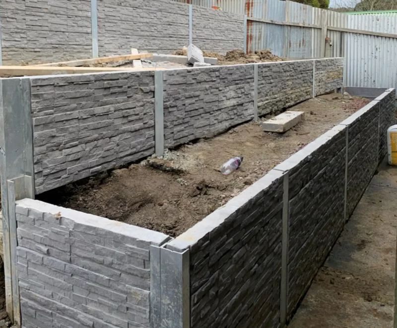 Backayrd Retaining Wall Construction Project in Progress Using the Charcoal Manhattan Stacked Stone Concrete Sleepers Supplied by Sunset Sleepers