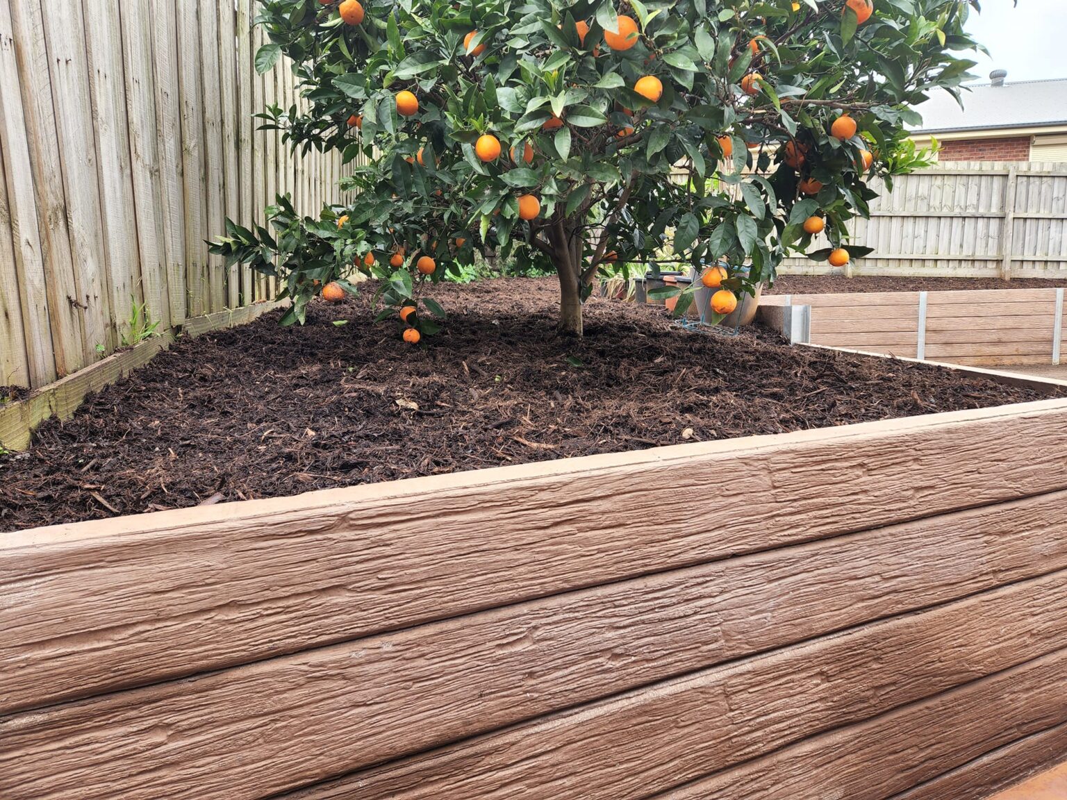 Backyard Garden Bed Retaining Wall Built by Dream View Landscape Using Jasper Brown Malibu Woodgrain Concrete Sleepers and Supplied by Sunset Sleepers