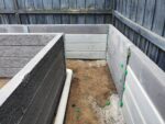 Backyard Garden Bed Retaining Wall Under Construction by Dream View Landscape Using Charcoal Malibu Woodgrain Concrete Sleepers and Supplied by Sunset Sleepers
