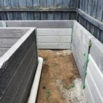 Backyard Garden Bed Retaining Wall Under Construction by Dream View Landscape Using Charcoal Malibu Woodgrain Concrete Sleepers and Supplied by Sunset Sleepers
