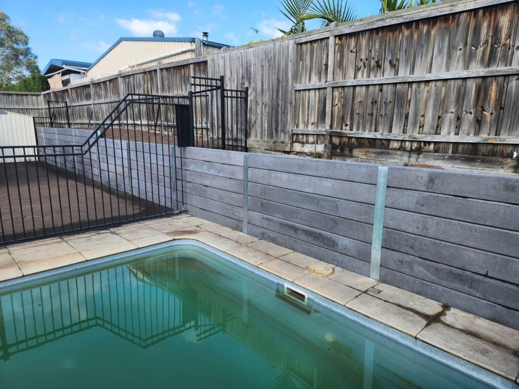 Backyard Pool Area Retaining Wall Built by Dream View Landscape Using Charcoal Marina Smooth Concrete Sleepers and Supplied by Sunset Sleepers