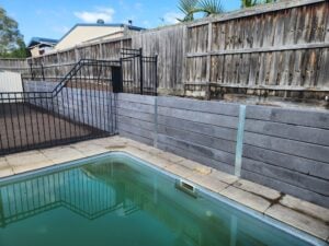 Backyard Pool Area Retaining Wall Built by Dream View Landscape Using Charcoal Marina Smooth Concrete Sleepers and Supplied by Sunset Sleepers