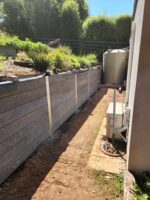 Backyard Retaining Wall Under Construction by Dream View Landscape Using Charcoal Malibu Woodgrain Concrete Sleepers and Supplied by Sunset Sleepers