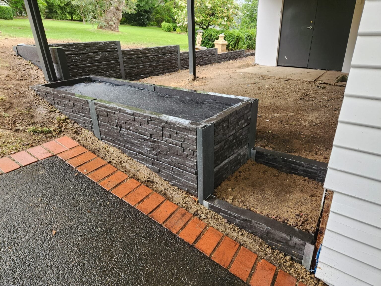 Completed Garden Bed Retaining Wall by Dream View Landscape Using Charcoal Manhattan Stacked Stone Concrete Sleepers and Supplied by Sunset Sleepers