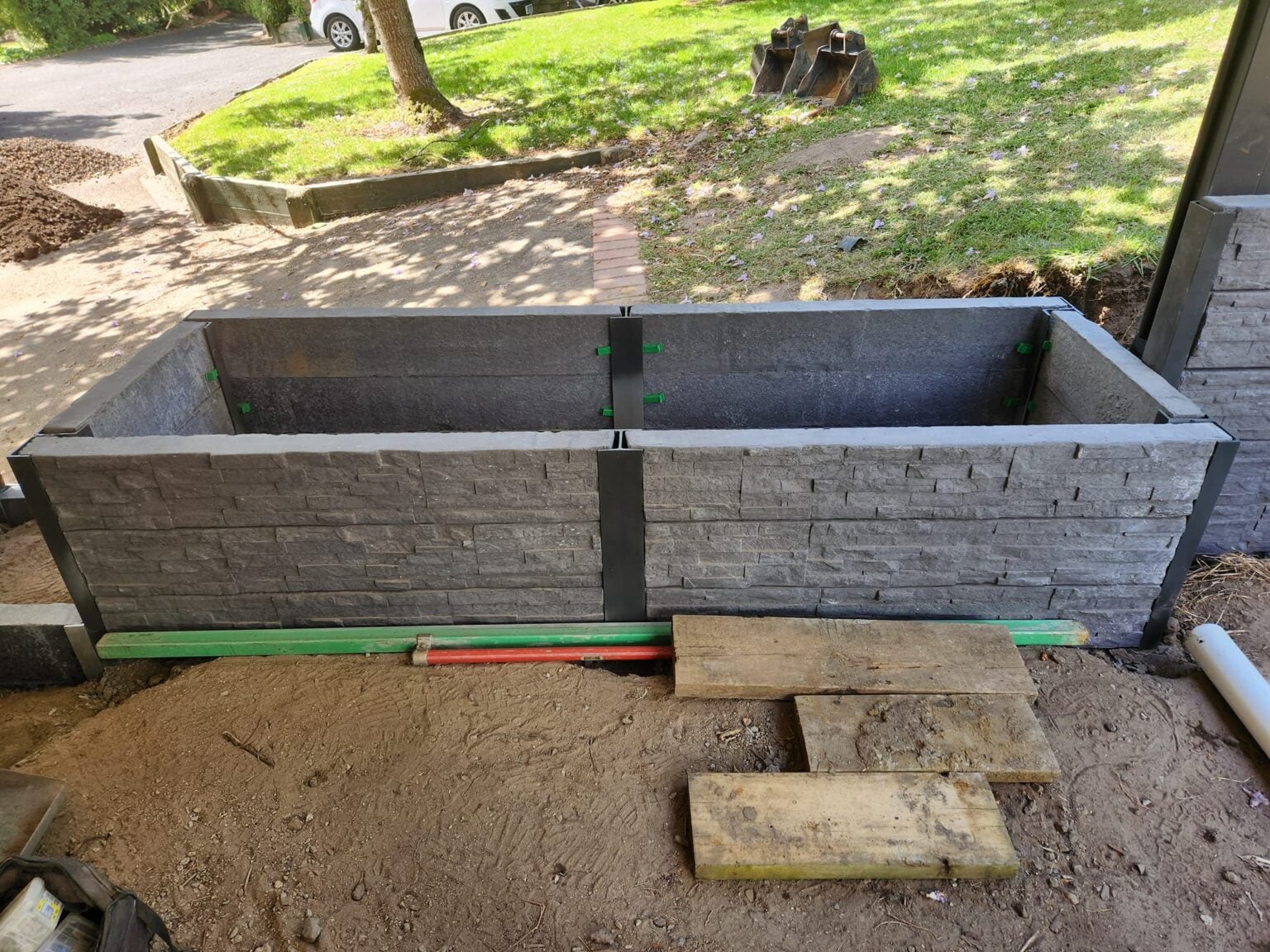 Garden Bed Retaining Wall Under Construction by Dream View Landscape Using Charcoal Manhattan Stacked Stone Concrete Sleepers and Supplied by Sunset Sleepers