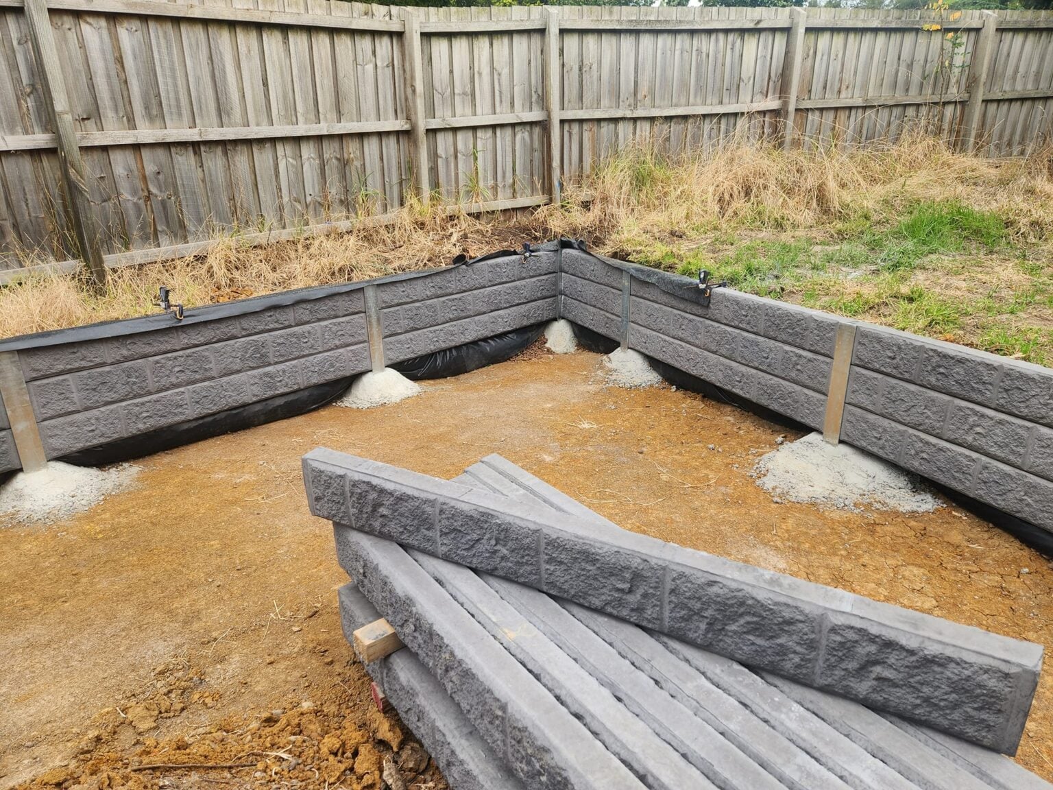 New Small Retaining Wall Under Construction by Dream View Landscape Using Charcoal Arizona Block face Concrete Sleepers and Supplied by Sunset Sleepers
