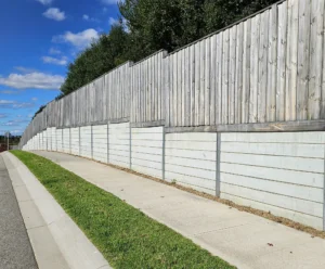 Gallery 16 Plain Grey Smooth Concrete Sleepers in The Marina Range used as an Under Timber Fence Retaining Wall Project and Supplied by Sunset Sleepers