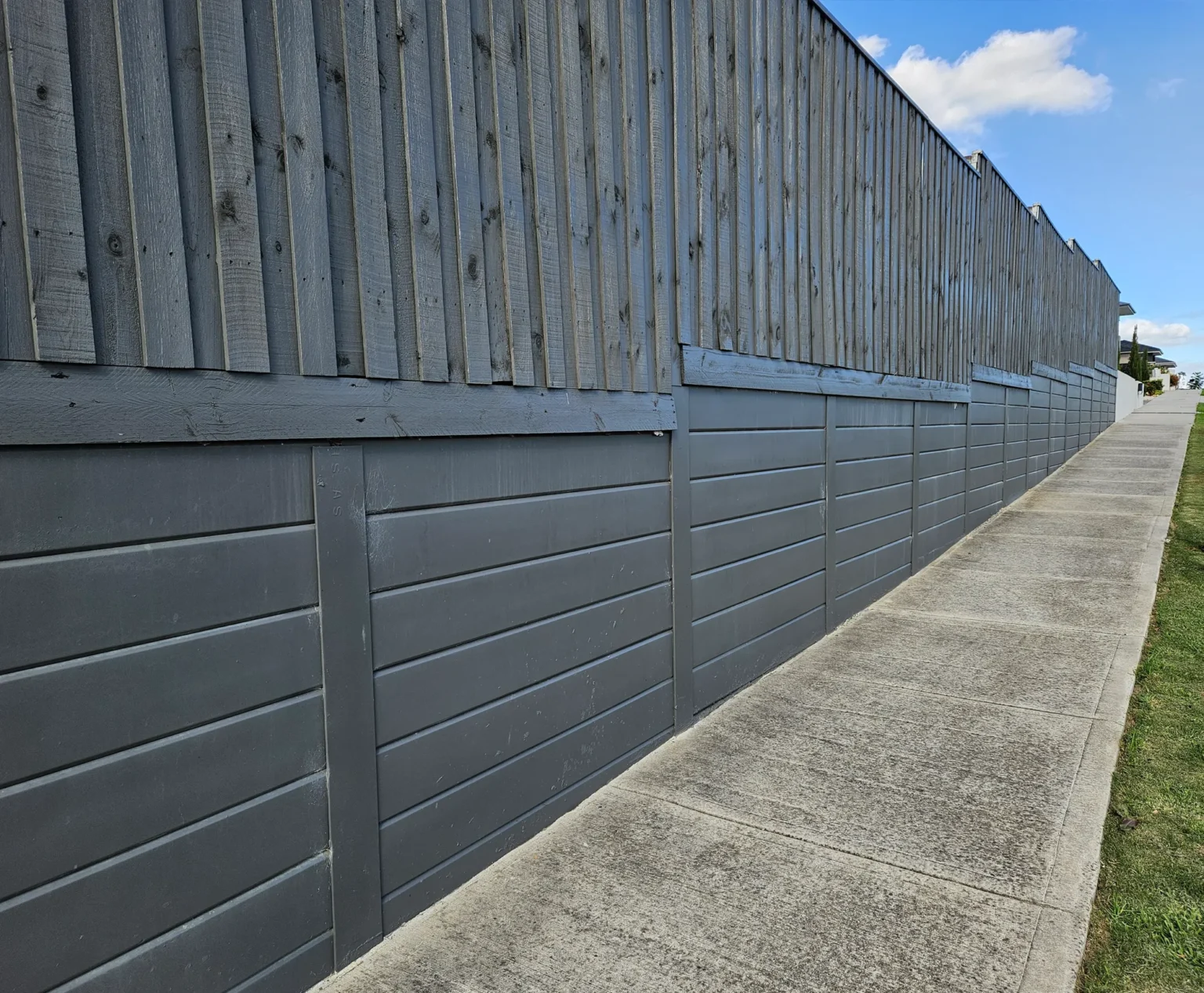 Plain Smooth Concrete Sleepers in The Marina Range used in an Under Timber Fence Retaining Wall Project and Painted On and Supplied by Sunset Sleepers