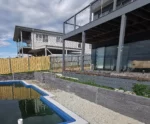 Progress Shot of a Retaining Wall Construction Around the Backyard Swimming Pool in San Remo Victoria Using the Charcoal Manhattan Stacked Stone Concrete Sleepers