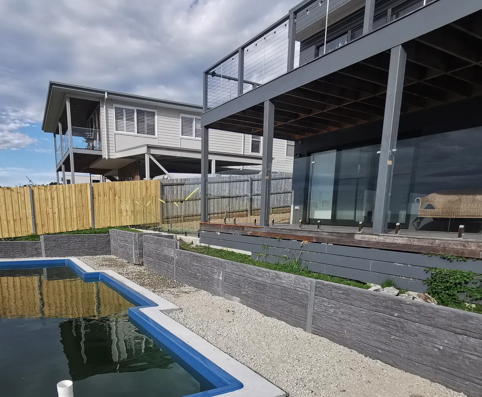 Progress Shot of a Retaining Wall Construction Around the Backyard Swimming Pool in San Remo Victoria Using the Charcoal Manhattan Stacked Stone Concrete Sleepers