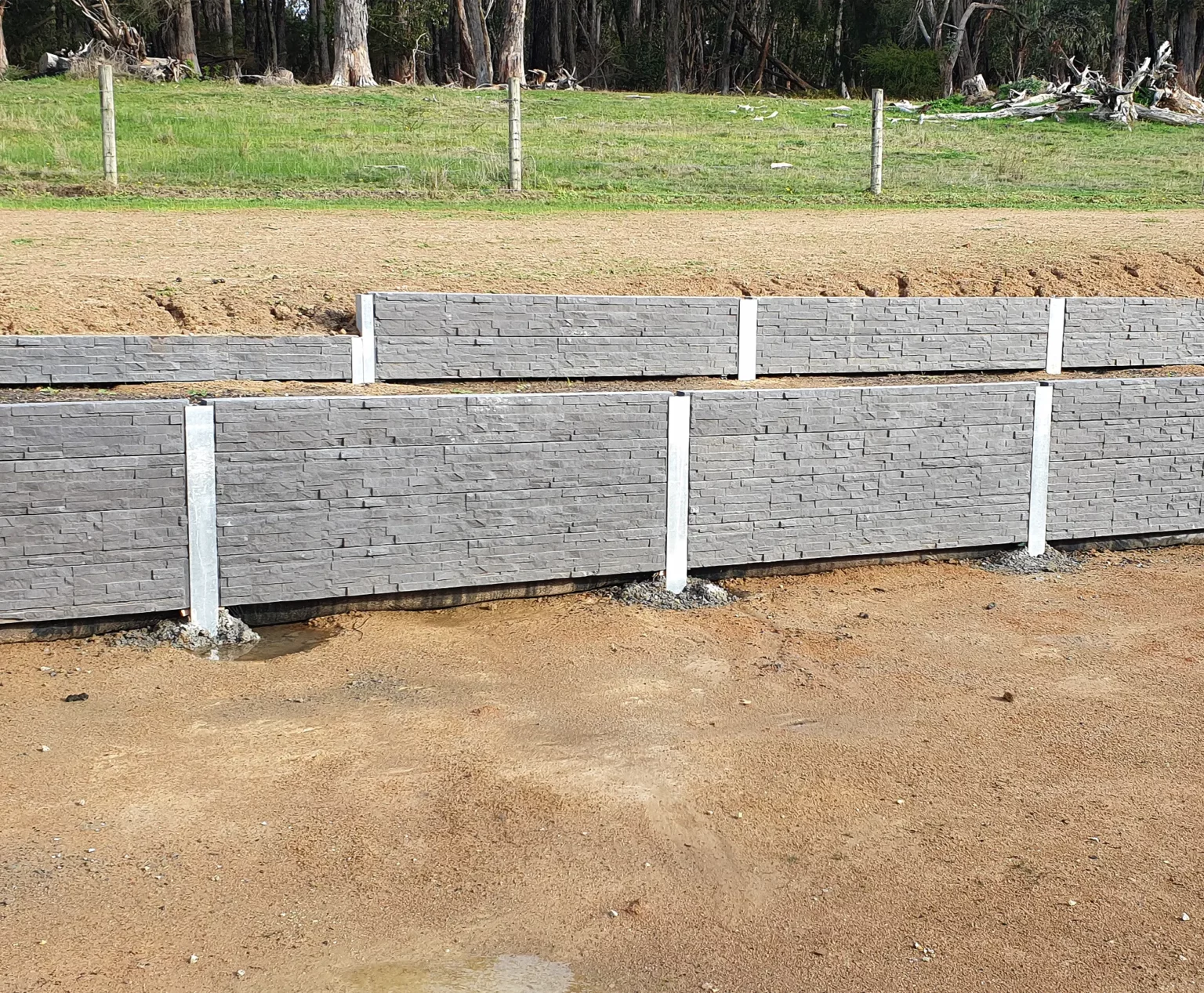 Rural Retaining Wall Project in Progress using The Charcoal Manhattan Stacked Stone Concrete Sleepers Supplied by Sunset Sleepers