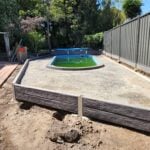Small Retaining Wall Construction Around Pool Area Built Dream View Landscape Using Charcoal Malibu Woodgrain Concrete Sleepers and Supplied by Sunset Sleepers
