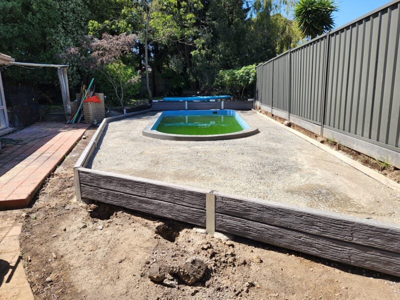 Small Retaining Wall Construction Around Pool Area Built Dream View Landscape Using Charcoal Malibu Woodgrain Concrete Sleepers and Supplied by Sunset Sleepers