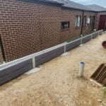 Small Side of House Boundary Retaining Wall Being Constructed by Dream View Landscape Using Charcoal Malibu Woodgrain Concrete Sleepers and Supplied by Sunset Sleepers