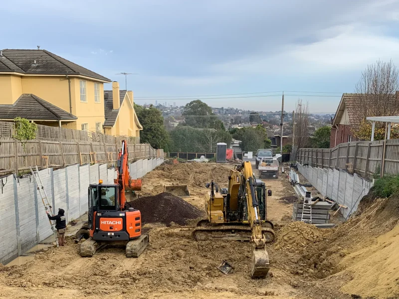 Large Boundry Retaining Wall Being Constructed using The Marina Smooth Concrete Sleepers in Plain Grey - Constructed by the team at JBS Retaining Walls & Excavations and Supplied by Sunset Sleepers